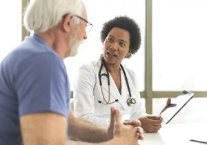 Serious retired man consulting with doctor