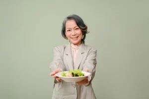 a senior woman holding a bowl of salad