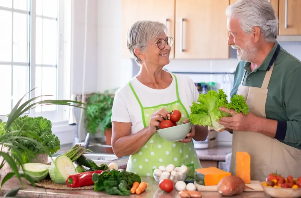 a senior couple holding their homegrown vegetables in their kitchen