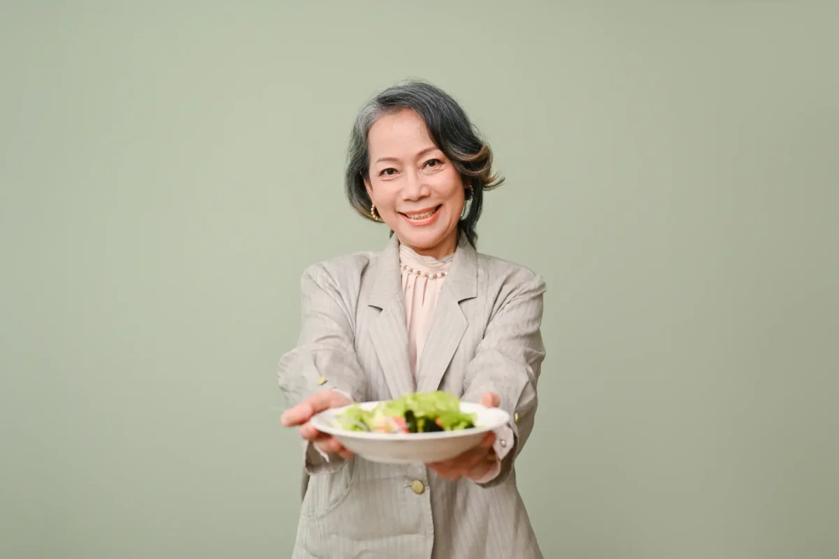 a senior woman holding a bowl of salad